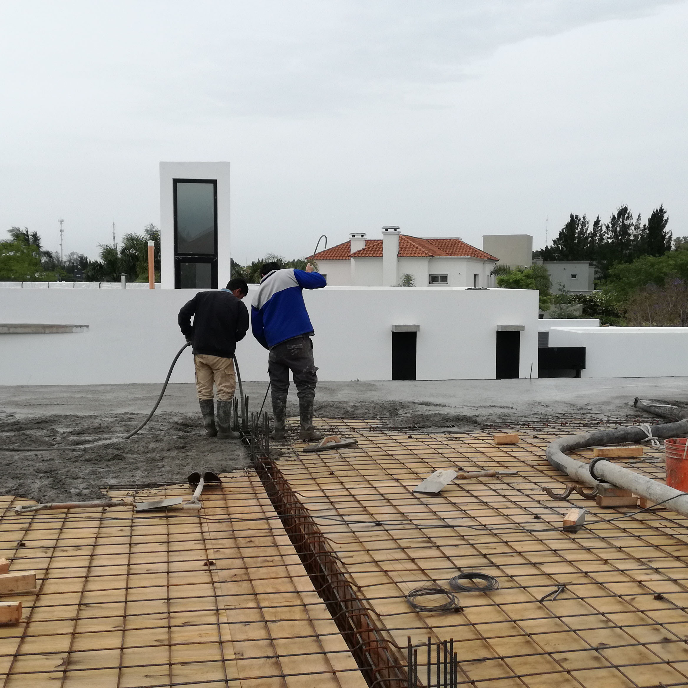 Construcción de vivienda con amplio espacio social, cocina y comedor integrados. Losa de hormigón