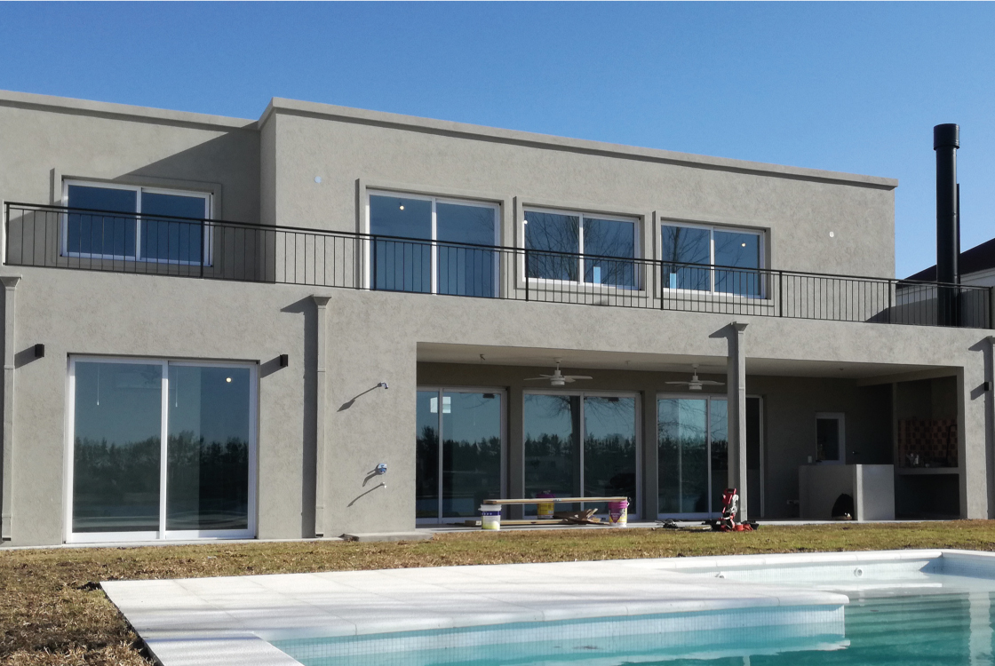 Exterior de la vivienda con amplio espacio social, cocina y comedor integrados. Vistas hacia el lago